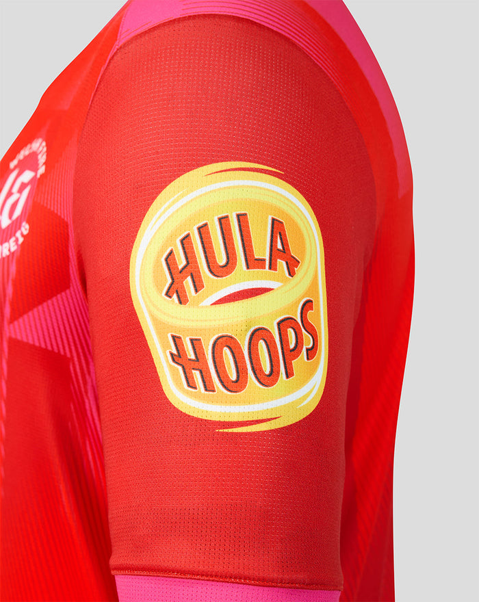 Close-up of red Welsh Fire jersey sleeve showing the yellow Hula Hoops sponsor patch.