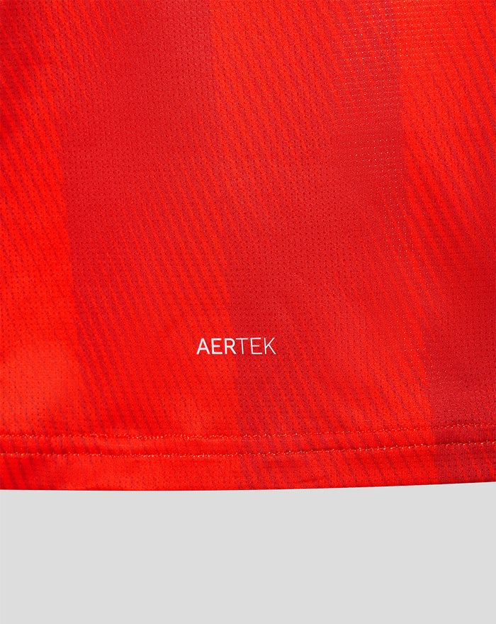 Close-up of red jersey fabric with AERTEK branding near the hem.