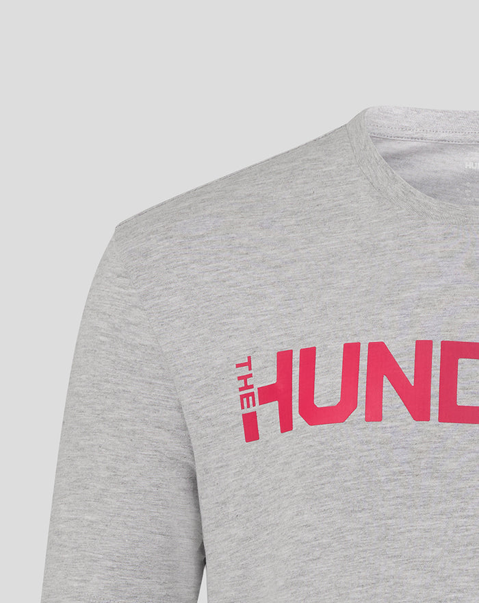 Close-up of grey fabric showing pink The Hundred logo across the chest