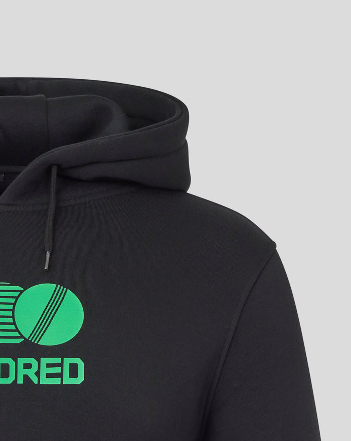 Close up of black hoodie hood with drawstrings and a partial bright green graphic on the chest